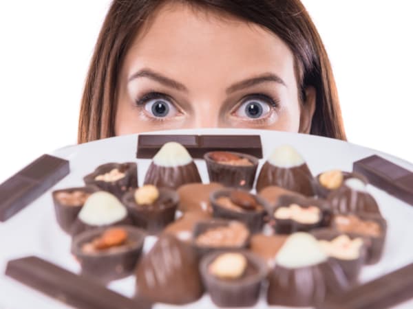 たくさんのチョコレートを凝視する女性。